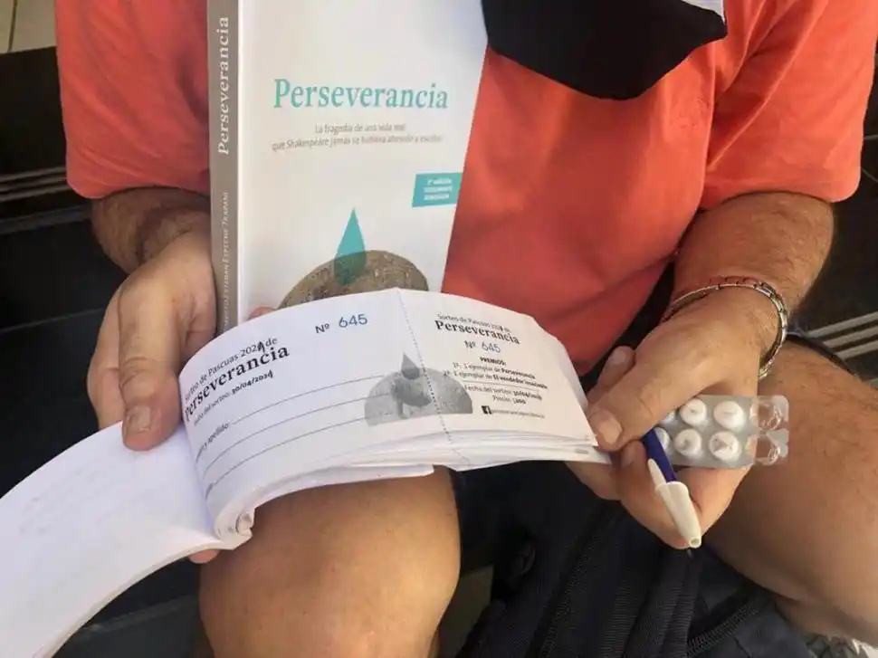 EL LIBRO Y SUS CORRESPONDIENTES RIFAS. Roberto Espeche Trapani muestra el talonario con el que, según recuerda, se acercó a la mesa del juez Enrique Pedicone y del vocal Daniel Leiva en la confitería Ohana.