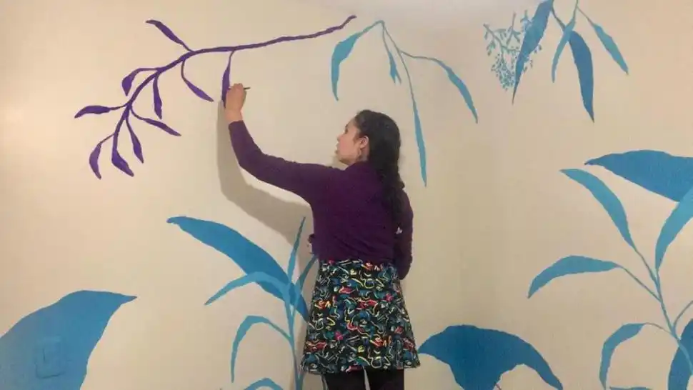 MURAL. La artista durante una intervención en la pared de una casa. 