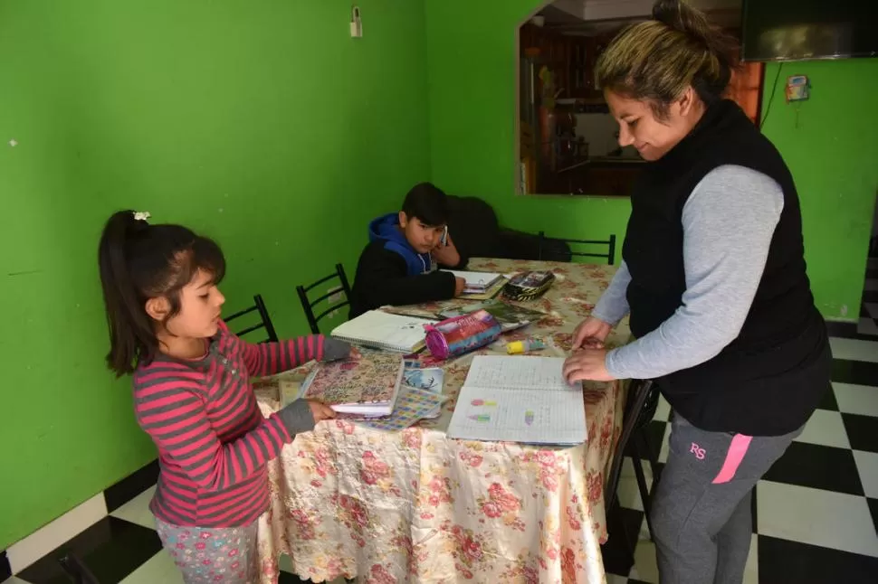 DEDICACIÓN EXCLUSIVA. Jésica Salvatierra ayuda a sus dos hijos. 