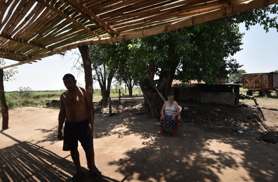 SIN LUZ NI AGUA. María Brizuela y su hijo juntaron agua de lluvia por que se cortó el servicio a causa de la crecida. Tampoco tienen luz.