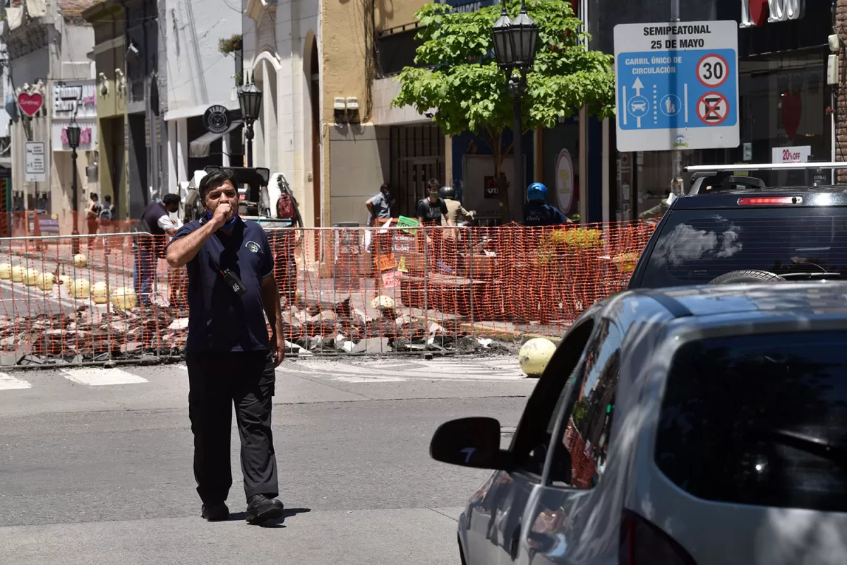 CAOS Y BOCINAZOS. Un agente de la Municipalidad desvía el tránsito de la 25 de Mayo por Santiago, algo que se extendería al menos por un mes. 