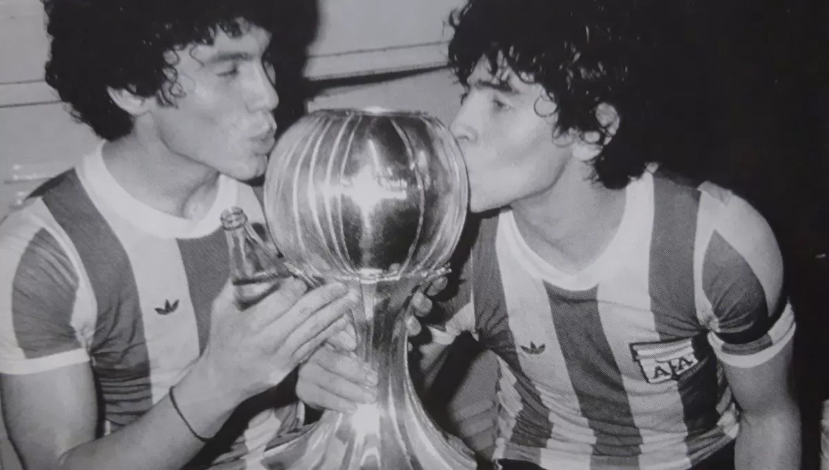 MÁS DE CUATRO DÉCADAS ATRÁS. El tucumano Juan José Meza y Diego Armando Maradona besan la copa conquistada por la selección argentina en el Mundial juvenil de Japón 1979.