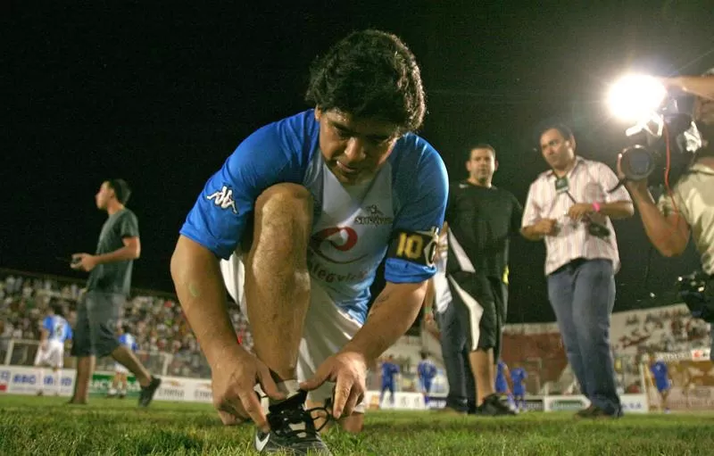 Diego Maradona se acomoda los botines antes de empezar el partido en La Ciudadela.