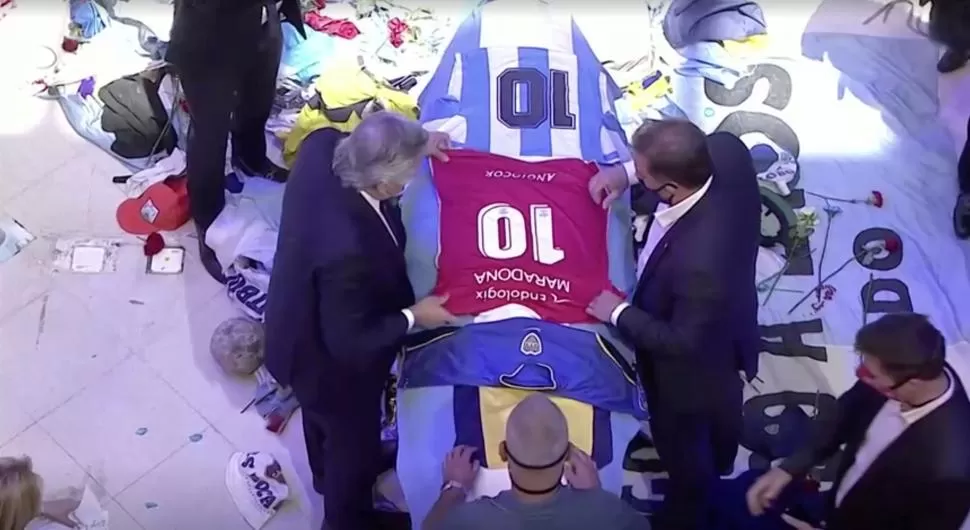 CONSTERNADO. El presidente Fernández deja una camiseta de Argentinos Juniors sobre el cajón, en el que ya estaban las de Boca y la de Gimnasia. reuters