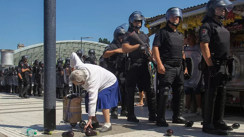 VERDURAZO. Una anciana recoje berenjenas del suelo tras una protesta. 