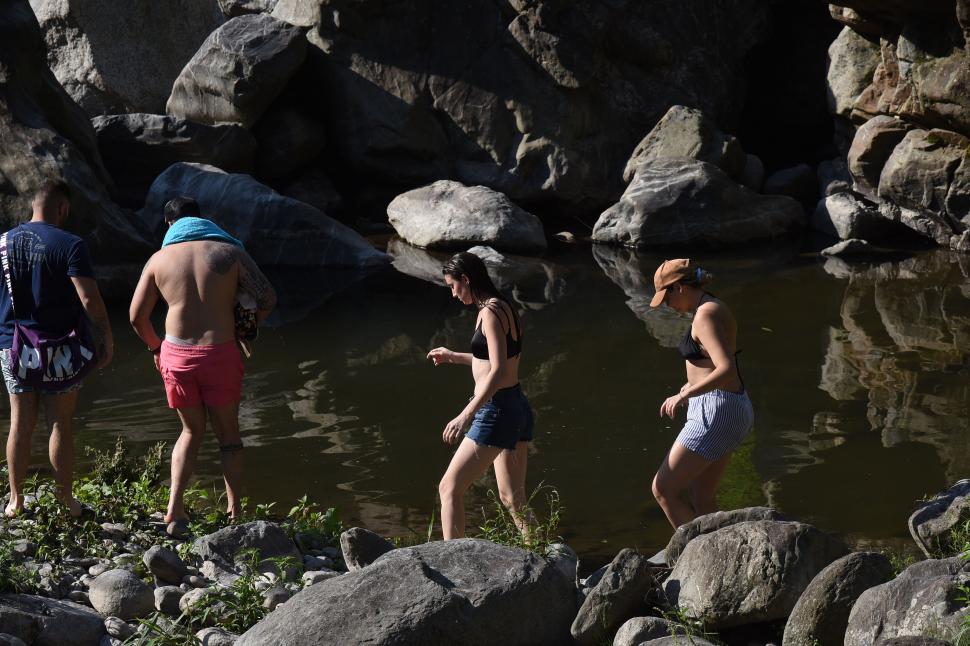 CAMINATA. Tres personas avanzan por la ribera del río en traje de baño. Hay quienes aprovechan para moverse en medio de la naturaleza.