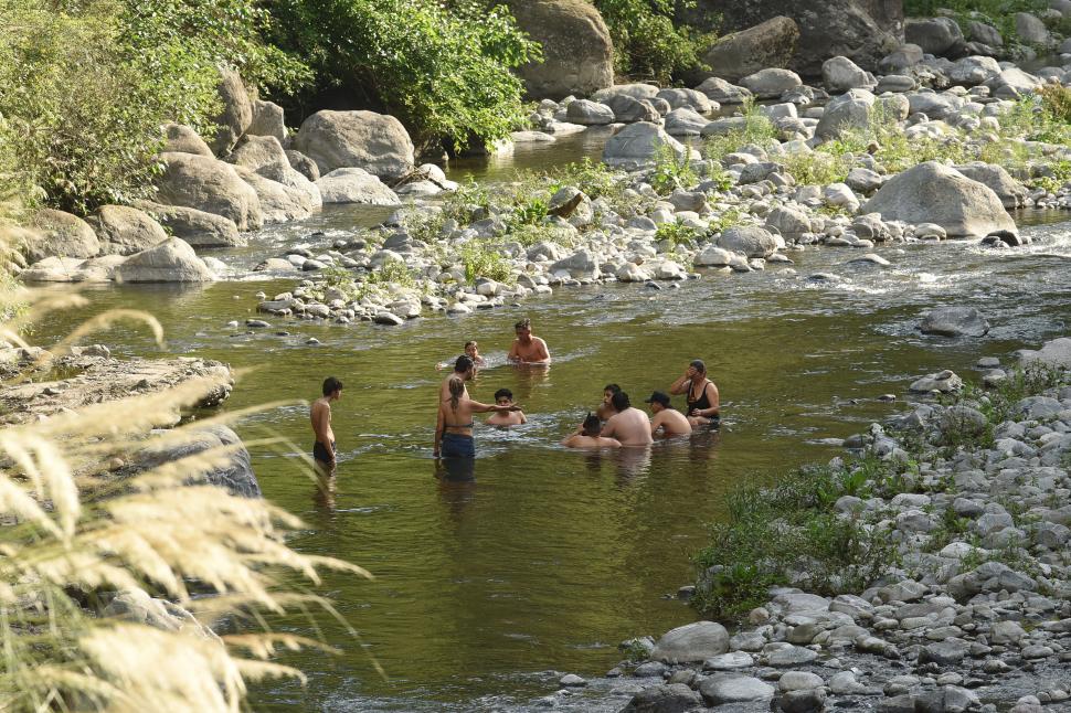 RONDA. Varias personas aprovechan una pequeña zona del río semejante a una pileta y charlan mientras se alivian del calor.