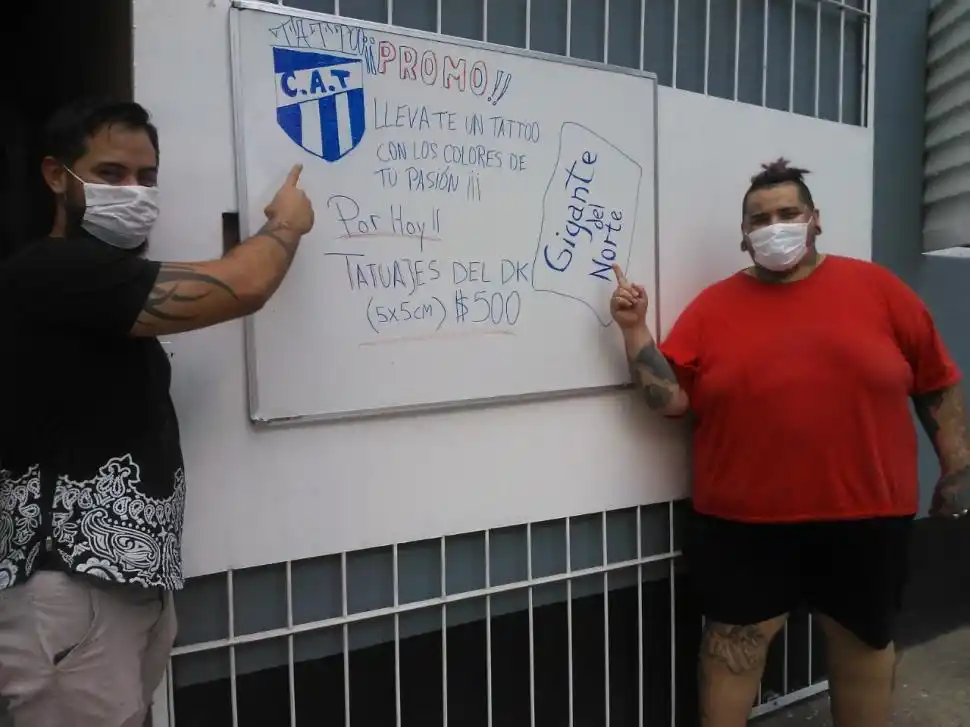 EN LA VEREDA. Martín junto a la pizarrón que está en la portón de la biblioteca.