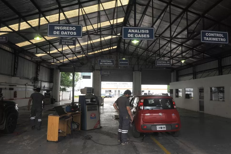INSPECCIÓN. Uno de los empleados de la planta de Verificación Técnica Vehicular (VTV) de la calle Saavedra 457 controla el estado de auto pequeño. 
