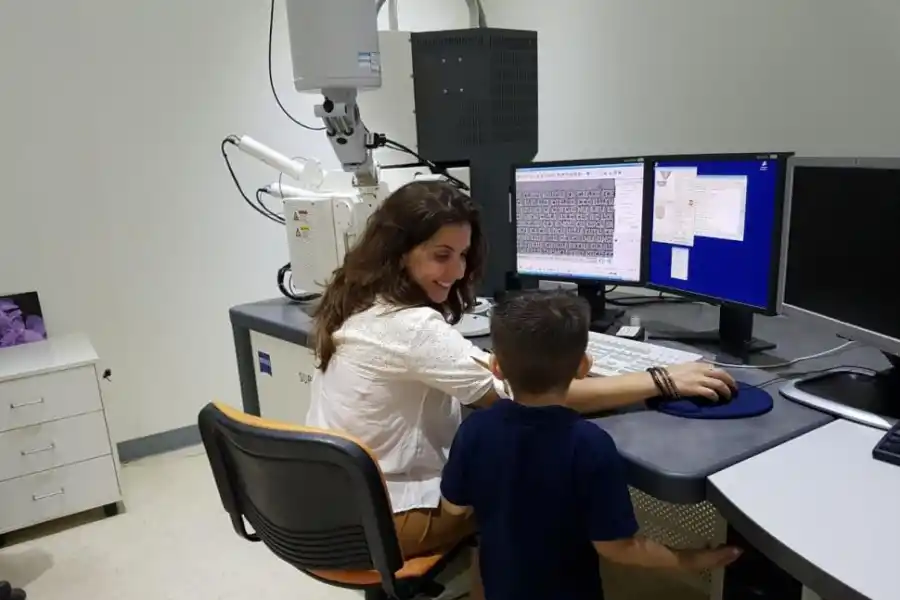 EN PANDEMIA. Científica/madre con el microscopio electrónico.