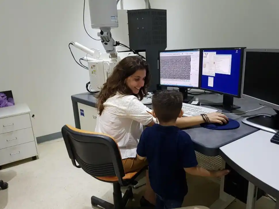 EN PANDEMIA. Científica/madre con el microscopio electrónico.