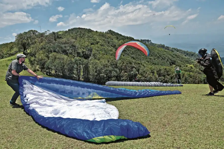 A PURO COLOR. Los parapentes tienen diversos diseños y sus telas muestran vistosos colores, que permiten seguirlos en pleno vuelo y distinguirlos cuando llegan al suelo. La labor de despliegue y repliegue es parte de la actividad.