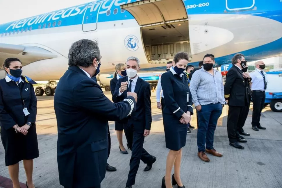 EN EZEIZA. El ministro de Transporte de la Nación, Mario Meoni, saluda a la tripulación de la aeronave que viajó a Rusia para buscar las vacunas.  