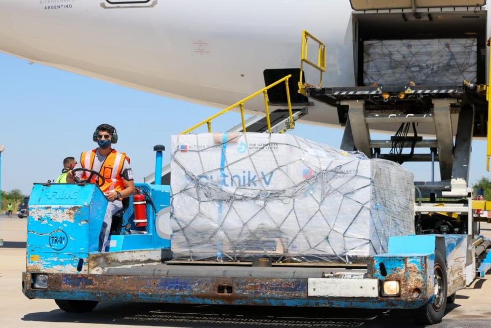 TRASLADO. Uno de los operarios del aeropuerto lleva las cajas hasta los camiones designados.