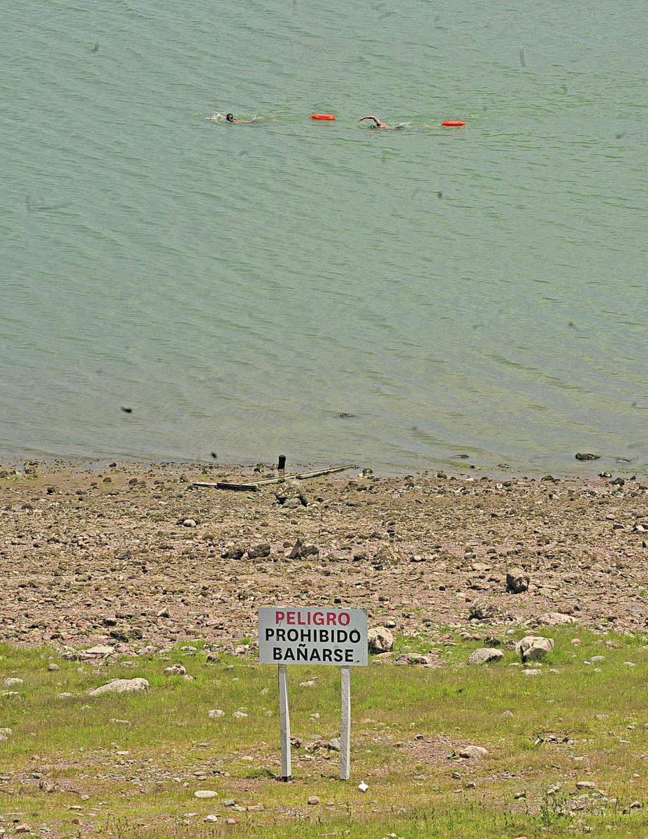 VIOLANDO LAS REGLAS. Pese a que el cartel es claro, dos personas nadan  cerca de la orilla del espejo de agua.