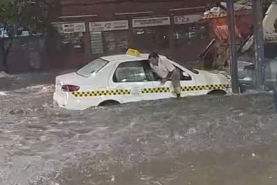 Un taxista salió de su auto por la ventanilla, porque estaba entrando agua al vehículo