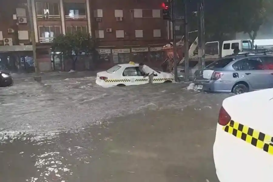 ESCAPE. Un taxista sale de su vehículo por la ventanilla para huir del agua que ingresaba. Ocurrió en la esquina de Roca y 9 de Julio.