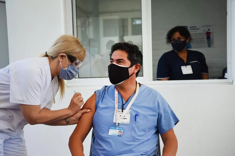 EN LA TRINCHERA. Mansilla, encargado de la mayoría de los hisopados, es vacunado por la ministra Chahla. 