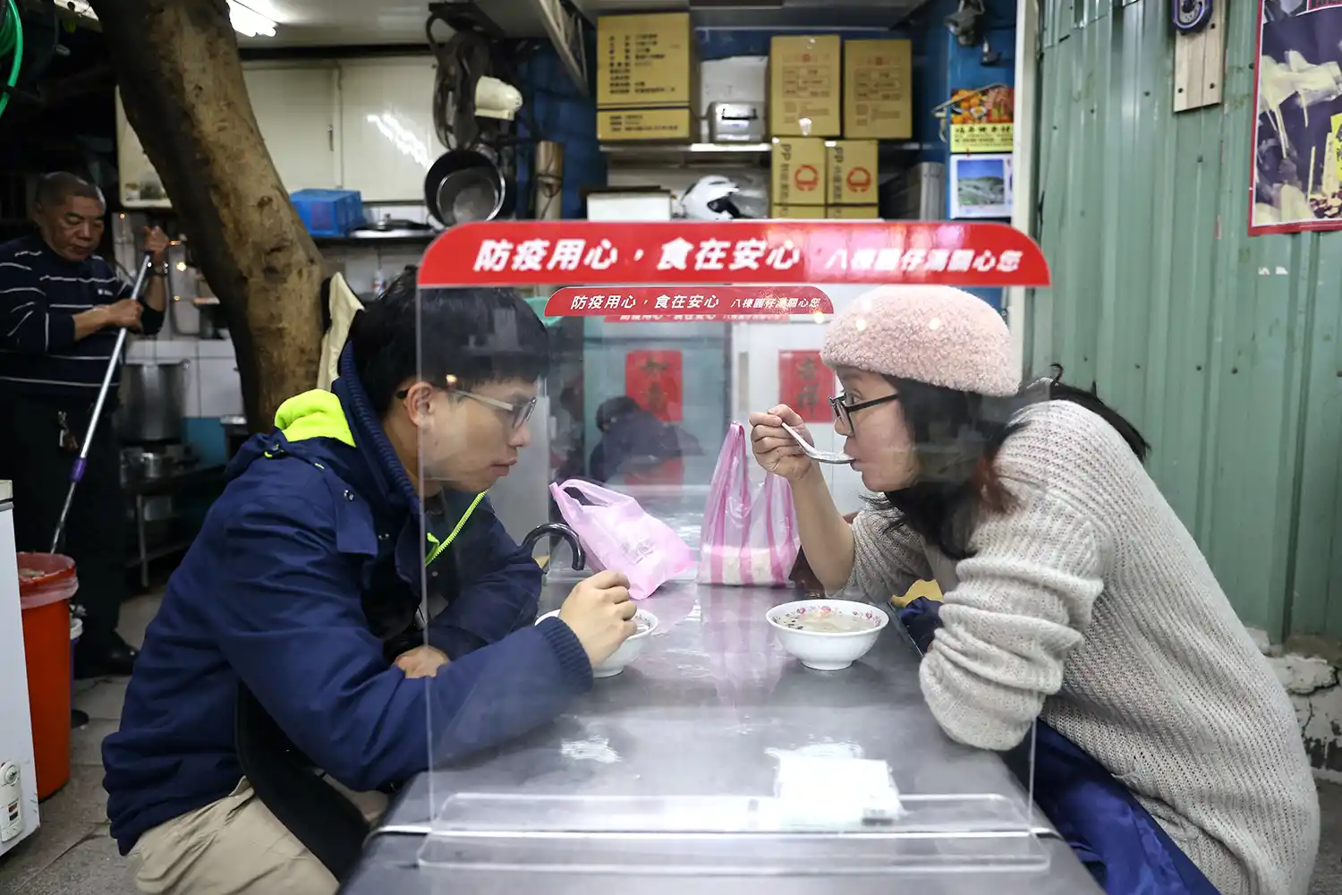 NUEVAS MANERAS. La pandemia del nuevo coronavirus obligó a cambiar las formas en que se desarrollan actividades cotidianas, como esta pareja que almuerza en el mercado céntrico de Taipei, en Taiwan, separados del resto de clientes por mamparas plásticas, para evitar contagios. 