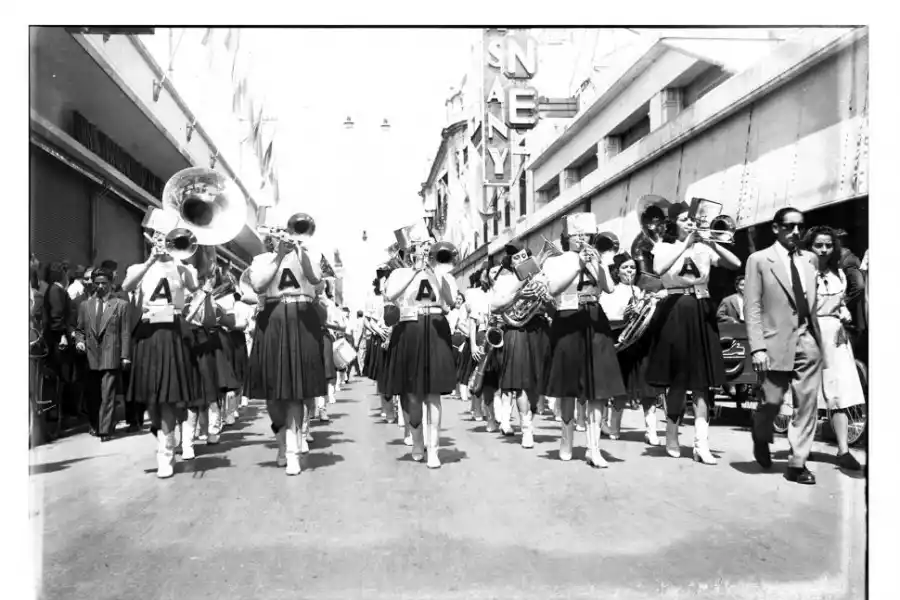  Calle Muñecas al 100. El 30 de abril de 1946 se inauguró, en las dos primeras cuadras de la arteria, un paseo peatonal al que se denominaba “Vía Blanca”. La medida municipal contó con el aval de los comerciantes de la zona. LA GACETA publicó en aquella fecha, que el paseo se habilitaba “a determinadas horas del día, las más propicias al paseo por el centro y a las visitas a las vidrieras, las horas del aperitivo del mediodía o del copetín de la tarde”. El cambio modificó la circulación de tres líneas de ómnibus: la A, la J y la F, que alteraron “eventualmente sus recorridos de 11 a 12.30 y de 18 a 20.30”, lo que nos da el rango horario de peatonalización. Como muestra la imagen, la “Vía Blanca” se vestía regularmente de fiesta con desfiles juveniles e importante convocatoria de gente.