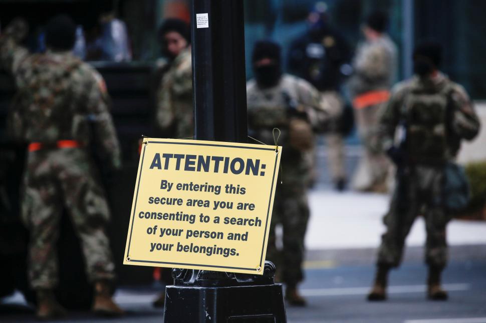 PRECAUCIÓN. Cerca del Capitolio, la Guardia Nacional advierte a los peatones, a través de un cartel, que al pasar por ahí aceptan ser cacheados. 