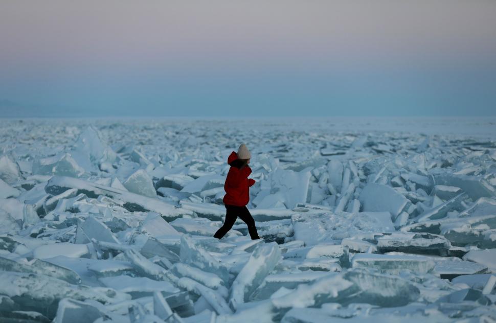 ALMATY. Una mujer camina sobre trozos de hielo en el congelado Embalse de Kapchagay, en Kasajistán.