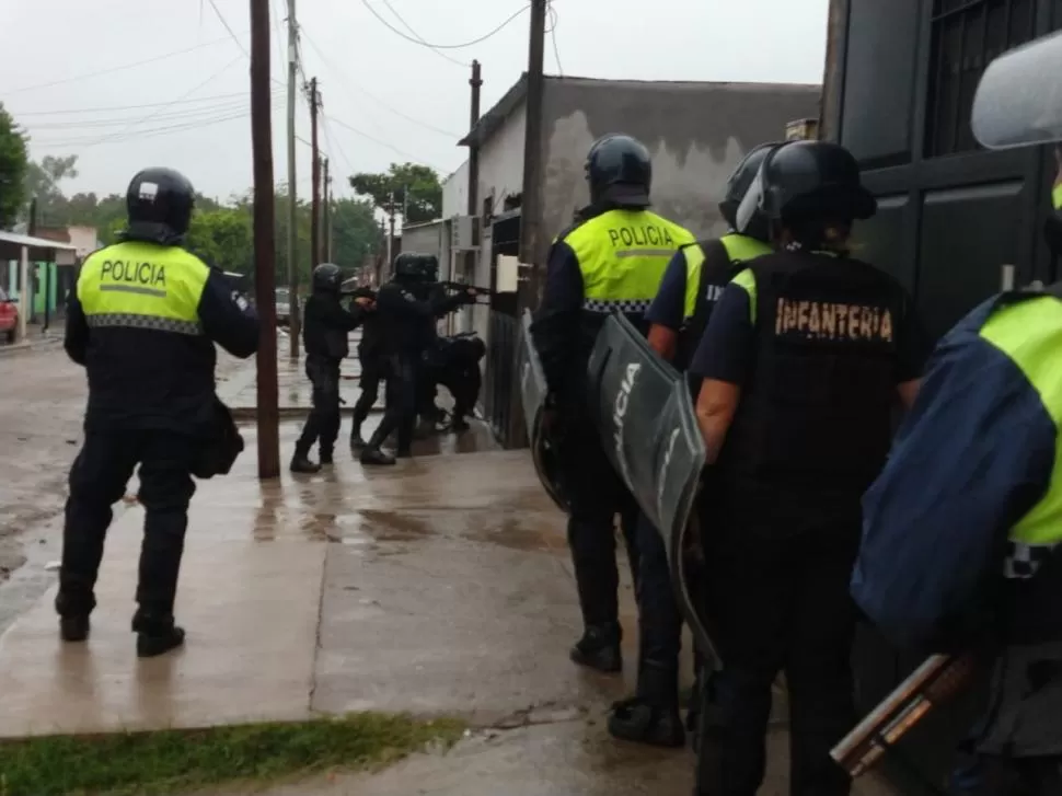 NO SE MUEVA NADIE. Efectivos de la Policía ingresan a un domicilio para detener a “Chino” Reguedero.  