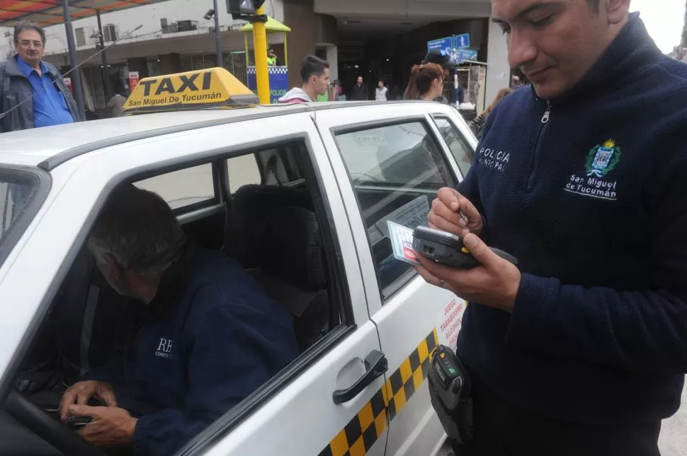 FISCALIZACIÓN EN LA VÍA PÚBLICA. Un inspector municipal controla a un taxista en el centro de la capital.  