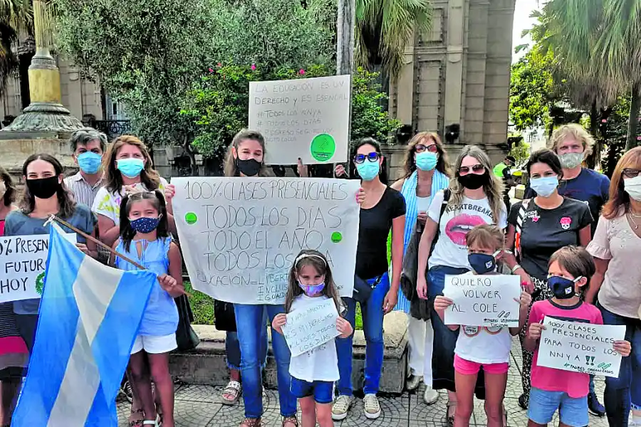 RECLAMO. Padres con sus hijos reclaman en la plaza Independencia.