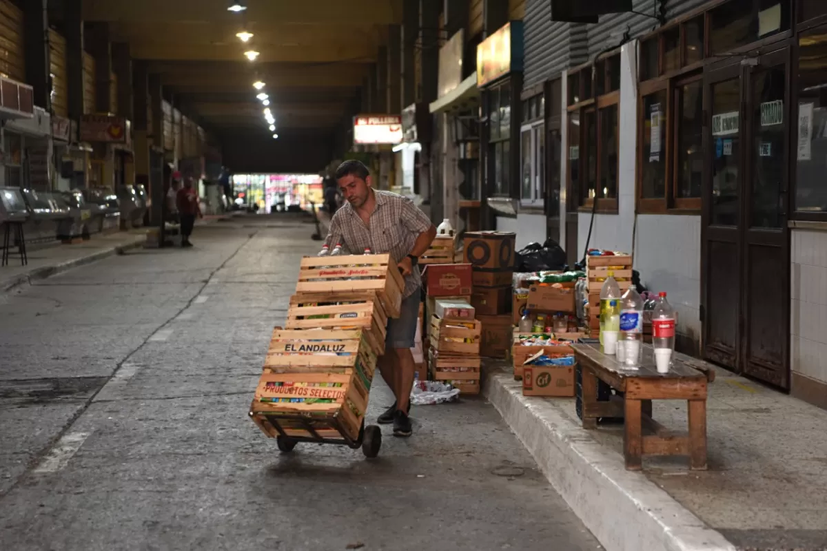 TRASLADO RÁPIDO. Un comerciante apura el paso para poder sacar de su local la mayor cantidad de productos y elementos durante su turno.