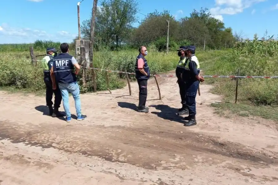 ESPERA. Los investigadores en la puerta del campo donde fue el hecho.