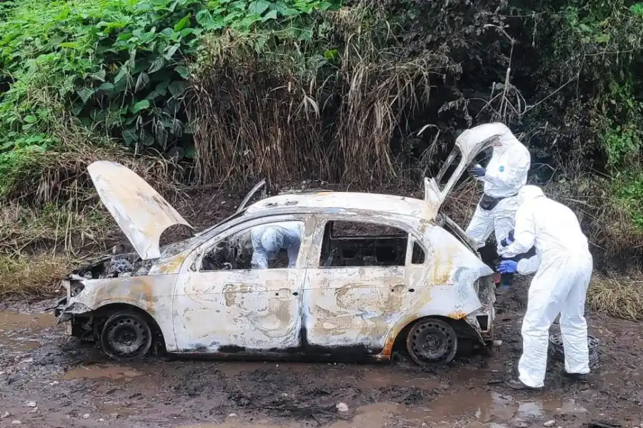 MACABRO. En El Sacrificio, los peritos analizan el auto incinerado donde se encontró un cuerpo calcinado.  