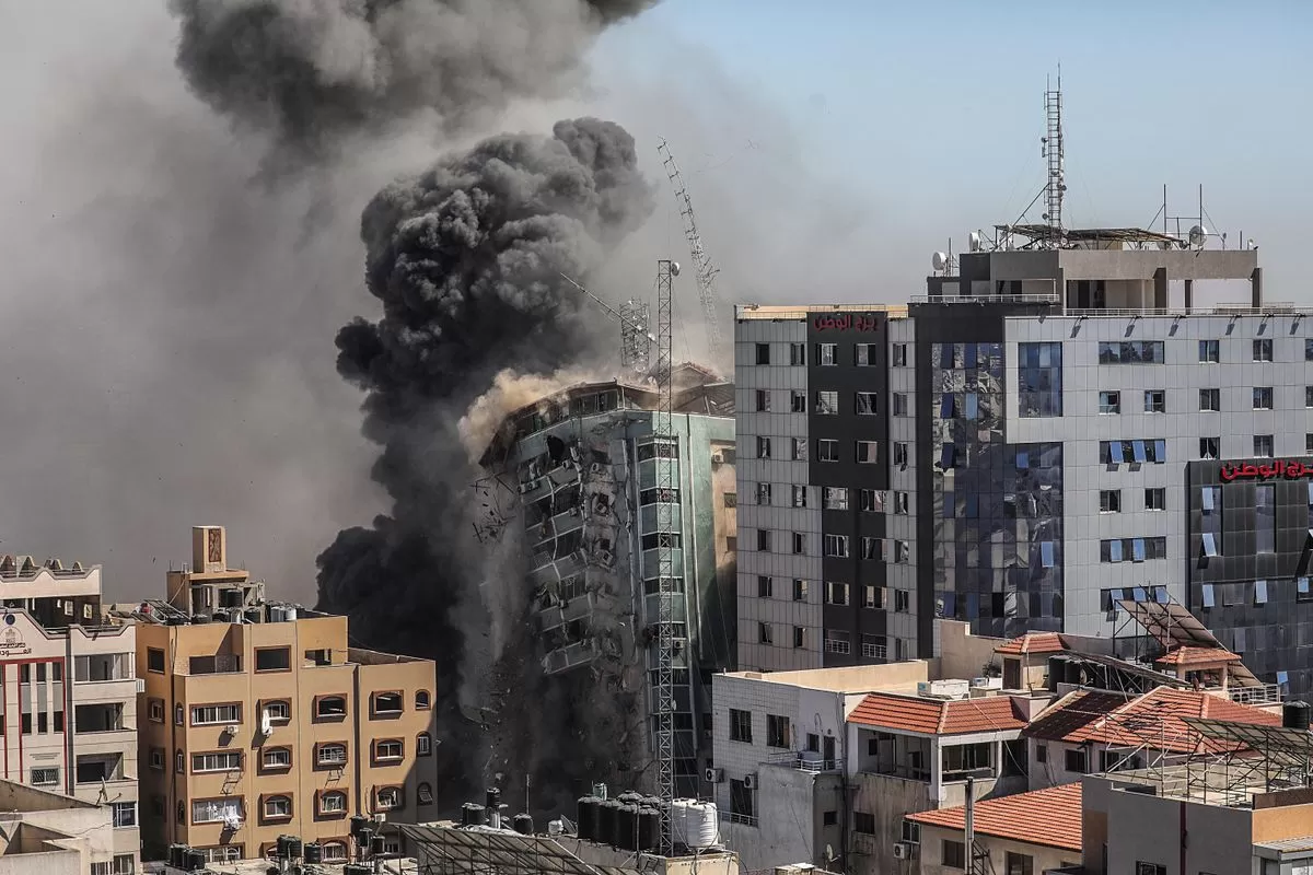 na columna de humo asciende de la torre de prensa bombardeada en Gaza.  EFE