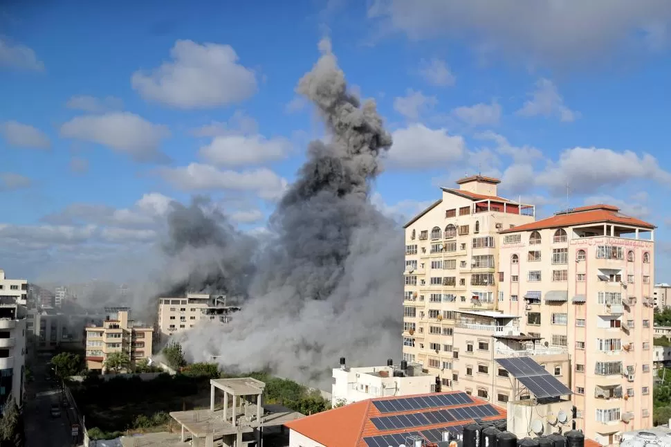 RESTOS. Una columna de humo se levanta entre los escombros de un edificio alcanzado por la artillería israelí. REUTERS 