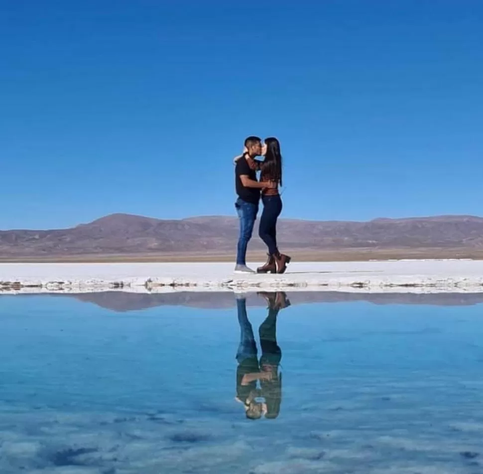 EL AMOR DEFINITIVAMENTE ESTÁ EN EL AIRE. Guillermo Acosta y Luciana Guzmán, a los besos en el salar de Jujuy y con su reflejo en una de las lagunas que componen el maravilloso paisaje. 
