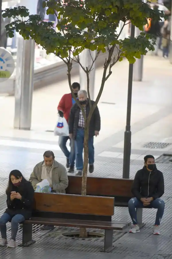TRES VARIANTES EN UN DESCANSO. Sólo uno de los sentados usa barbijo y de manera correcta