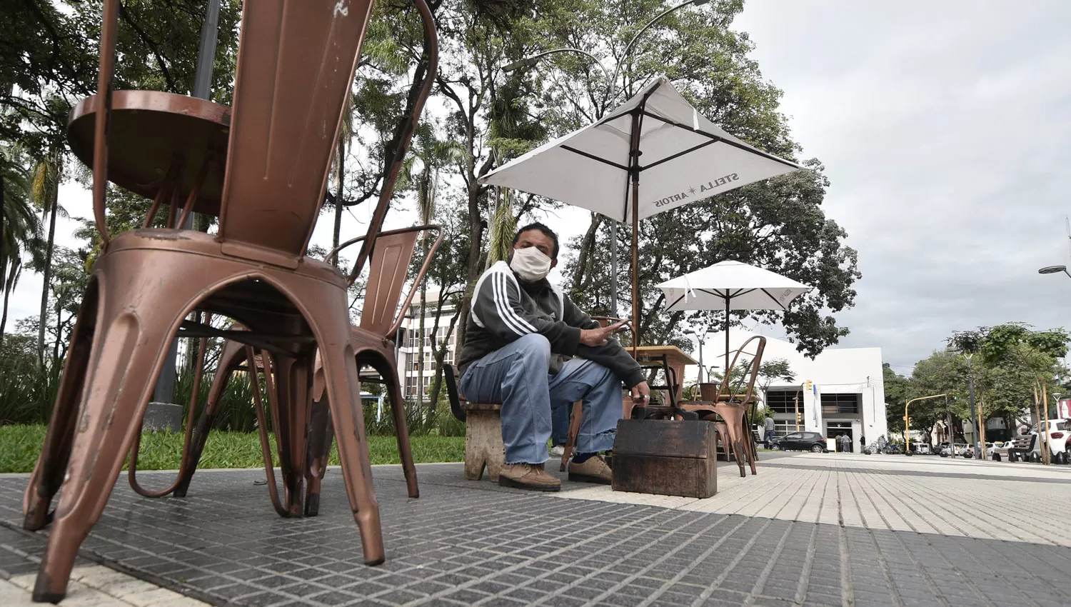 DÍA A DÍA. Pese a las restricciones, un hombre espera clientes para lustrar zapatos en la plaza de Concepción.
