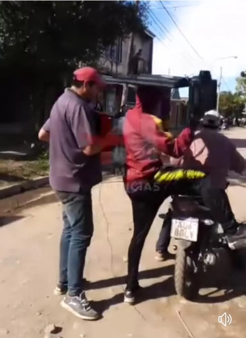 SECUENCIA DEL CAOS. Un hombre sale de la casa de la acusada con objetos y luego los carga en una moto.  