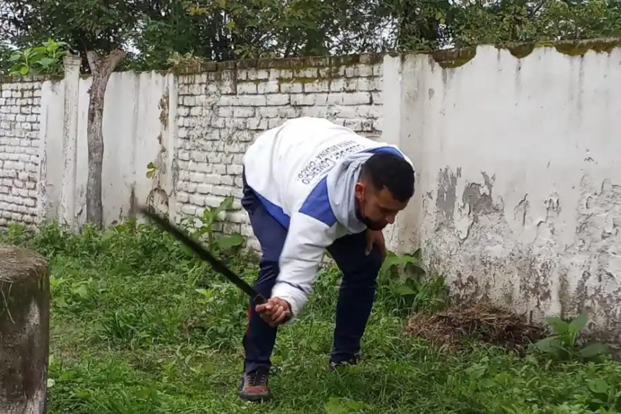 OFICIO. Franco, en plena tarea de desmalezamiento en el predio de una escuela.  