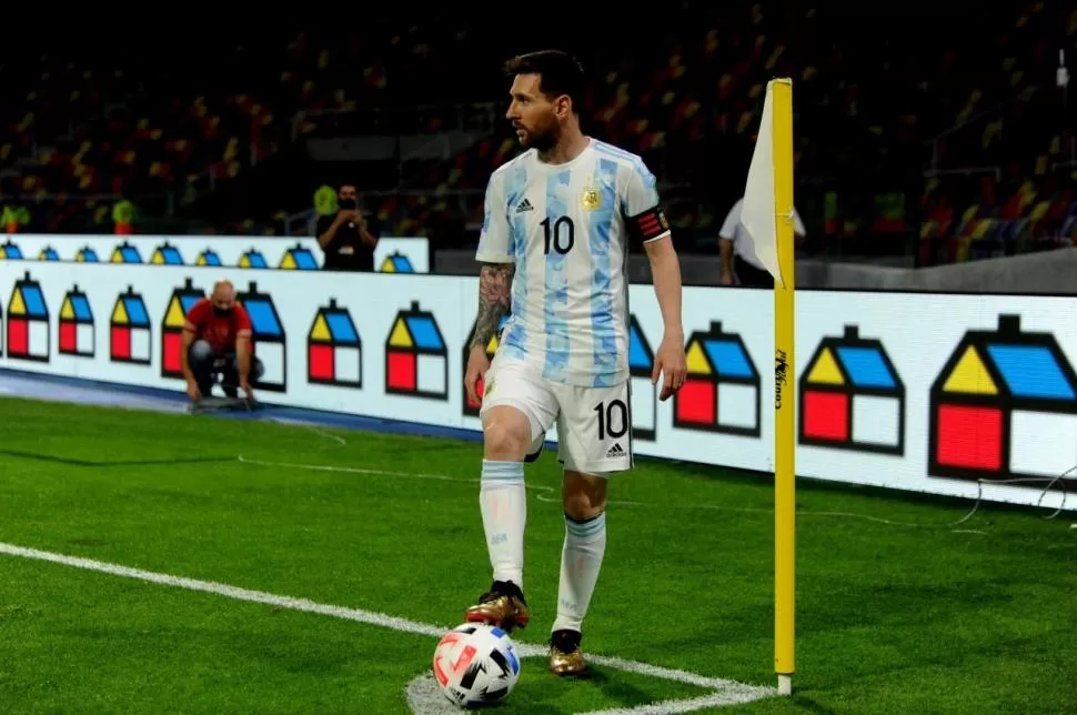 PELOTA AL PIE. Lionel Messi, dispuesto a tirar un córner, la vista en la posición de sus compañeros y con las instalaciones del estadio santiagueño de fondo. 