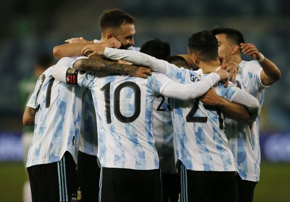 FELICIDAD. Luego de anotar el tercer gol de Argentina, el segundo en cuenta personal, se armó la ronda de festejo. El 10 argentino fue felicitado por su gran definición. 