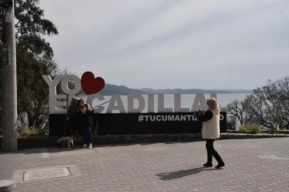 LUGAR PARA LA FOTO. Lago, montañas y una señal de identidad turística de Tucumán.  