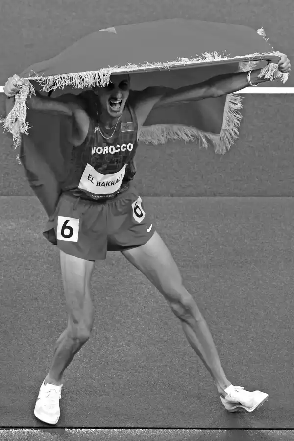 ¡ARRIBA MARRUECOS! Soufiane Elbakkali hace flamear su bandera después de haber obtenido la medalla dorada en la carrera de 3.000 metros.