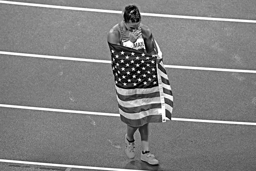 DORADA POR EL DISCO. La lanzadora norteamericana Valarie Allman se envuelve en su enseña después de obtener la medalla de oro.