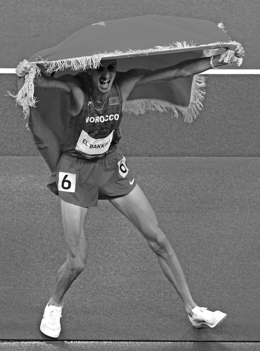 ¡ARRIBA MARRUECOS! Soufiane Elbakkali hace flamear su bandera después de haber obtenido la medalla dorada en la carrera de 3.000 metros.