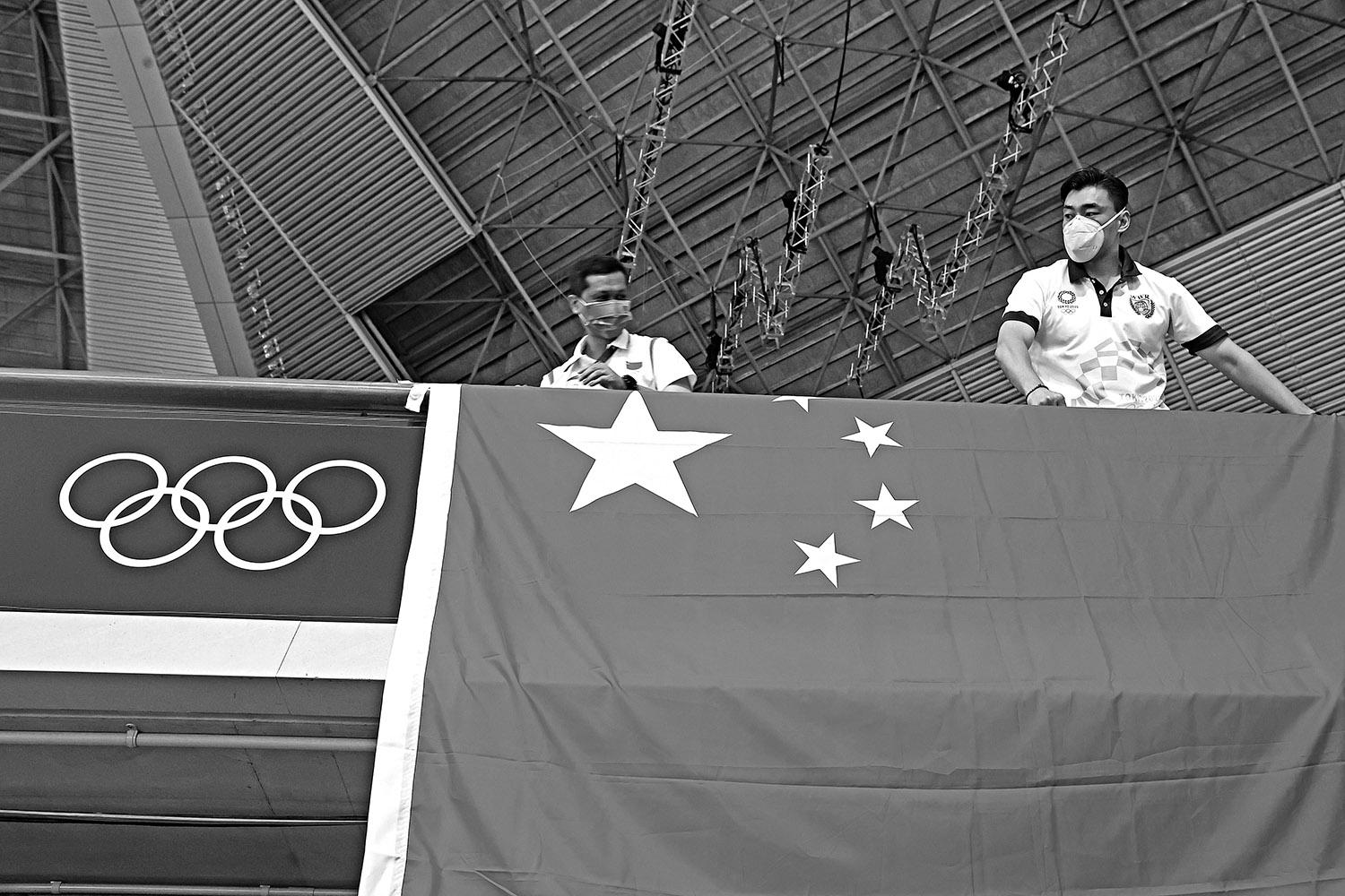 LAS ESTRELLAS CHINAS. Los miembros del equipo chino instalan su bandera en el centro de water polo Tatsumi, antes de los cuartos de final de mujeres entre España y China.