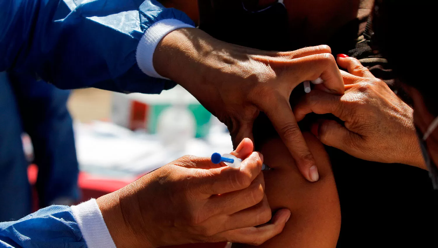 EN LA FRONTERA. Una migrante recibe la vacuna de Pfizer en un campamento ubicado en el estado de Tijuana. 