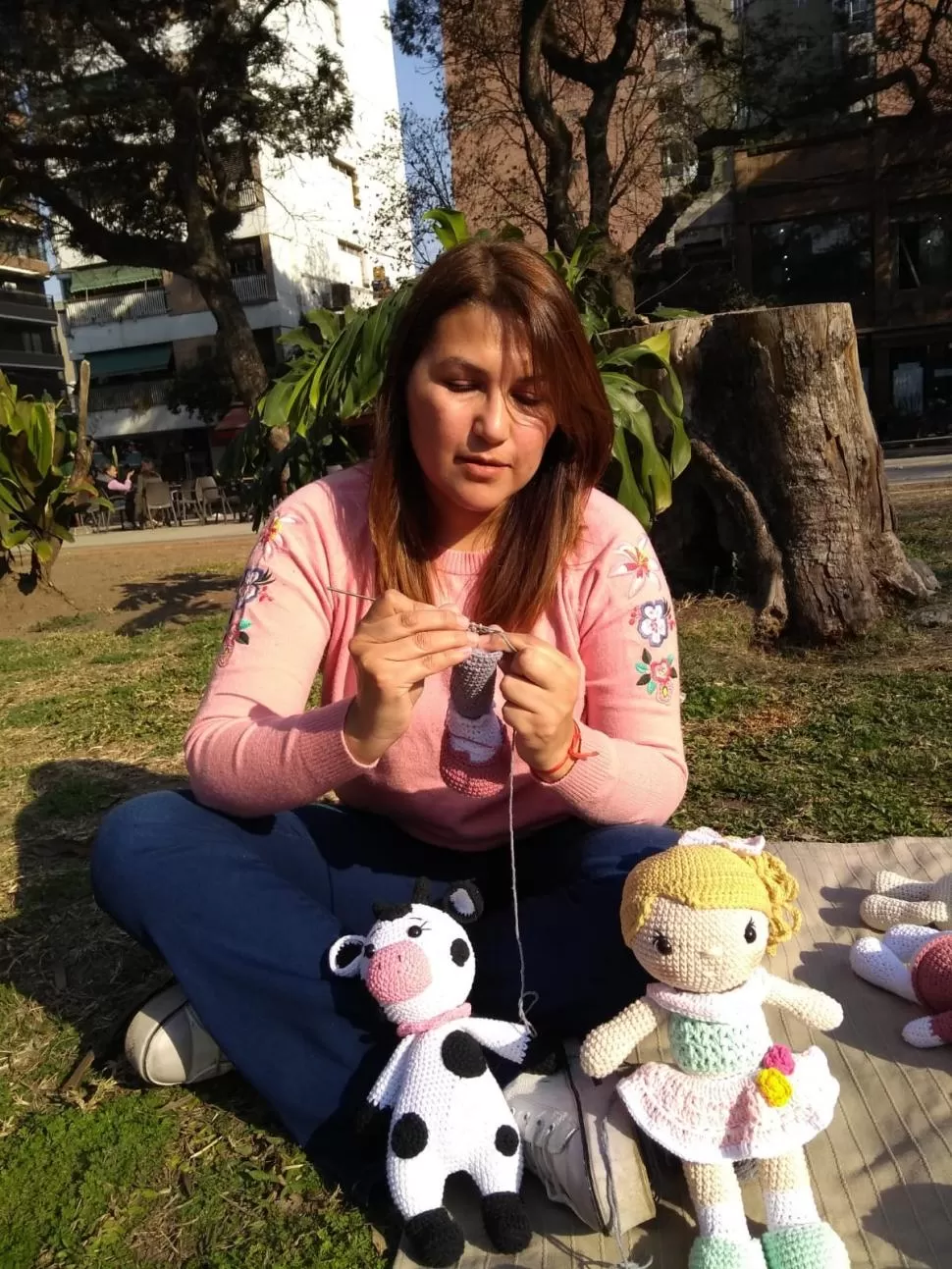 AUTODIDACTA. Así se describe Mariana Ruiz, quien posa con sus muiñecos tejidos en la plaza Urquiza. 