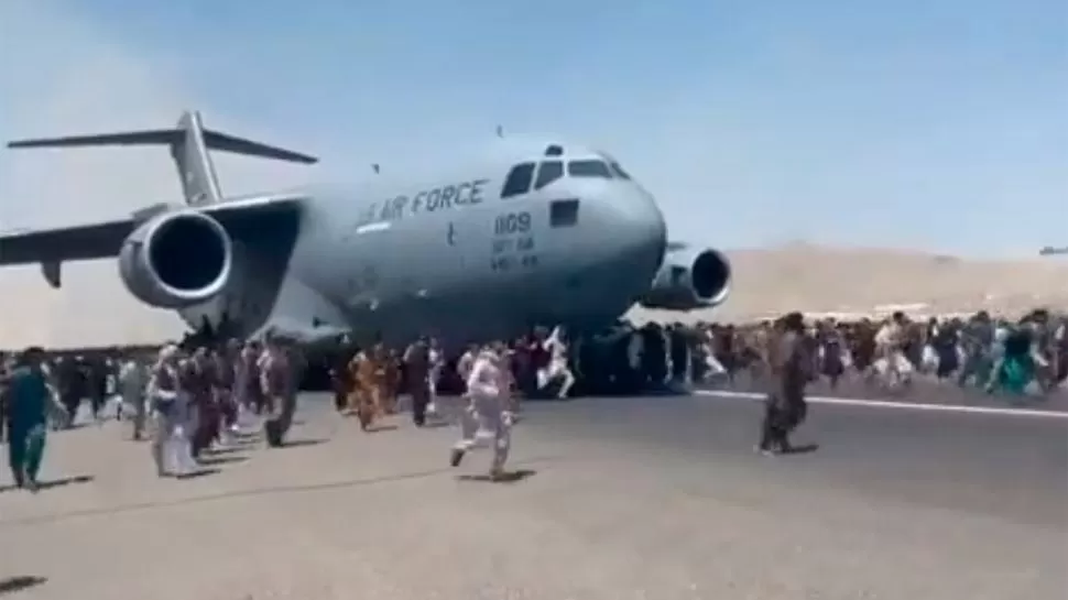 DESESPERACIÓN. Varias personas murieron al intentar colgarse de un avión estadounidense, mientras tratan de huir de Kabul, ocupada por los talibanes.  