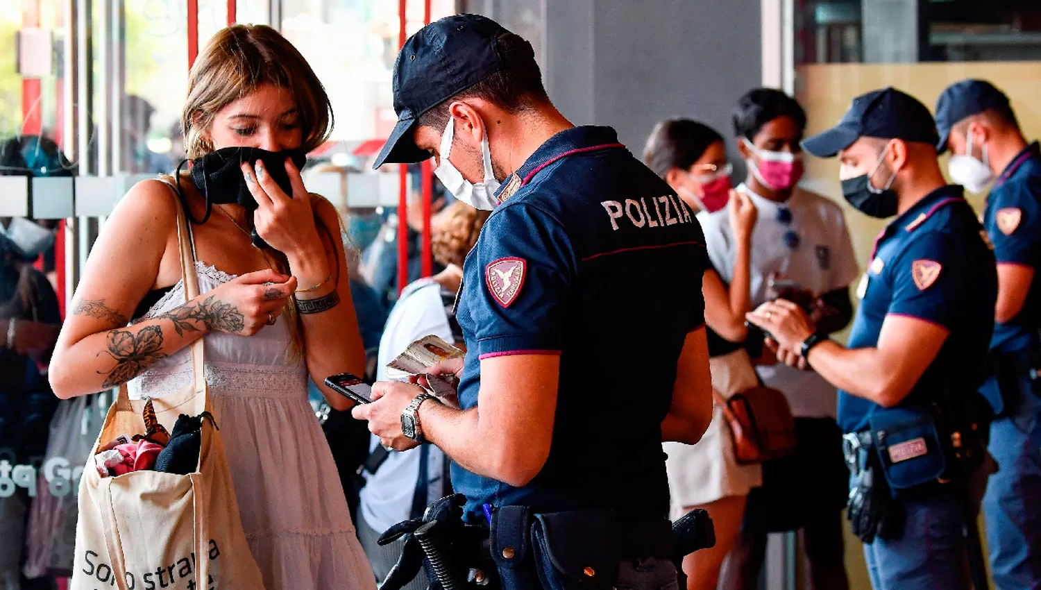 PASE VERDE. Policías controlan a los pasajeros en la estación de trenes de Milano, en Italia.